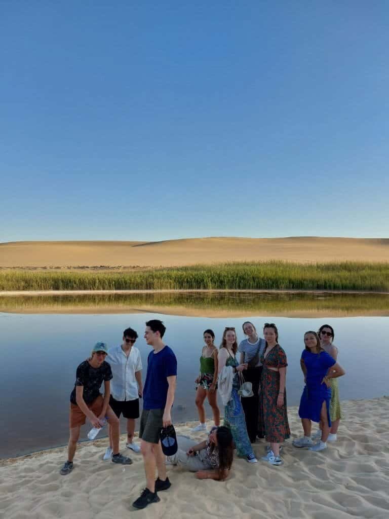 Crossroads group by a lake in Siwa Oasis at sunset