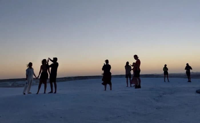 Travellers silhouetted on the White Desert at dusk