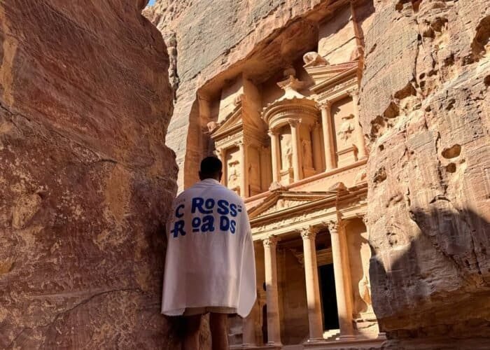 Traveller at the Siq entrance facing the Treasury in Petra