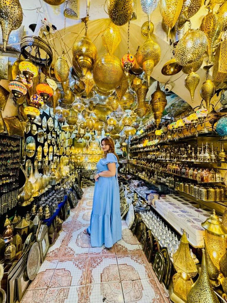 Traveller in a Moroccan souk shop full of brass lanterns and teapots
