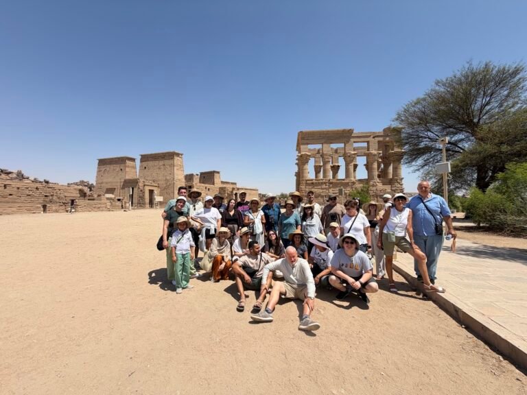 Travellers at Philae Temple in Aswan with Trajan's Kiosk behind them